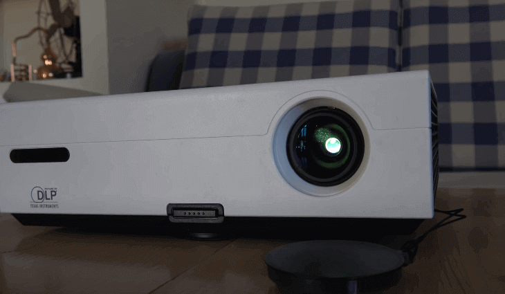 proyector blanco encedido encima de una mesa